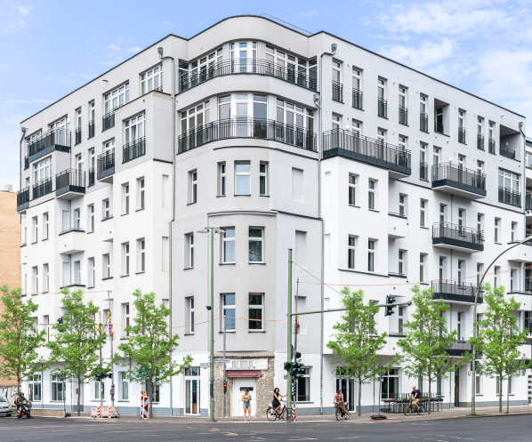 White period apartment building with street trees